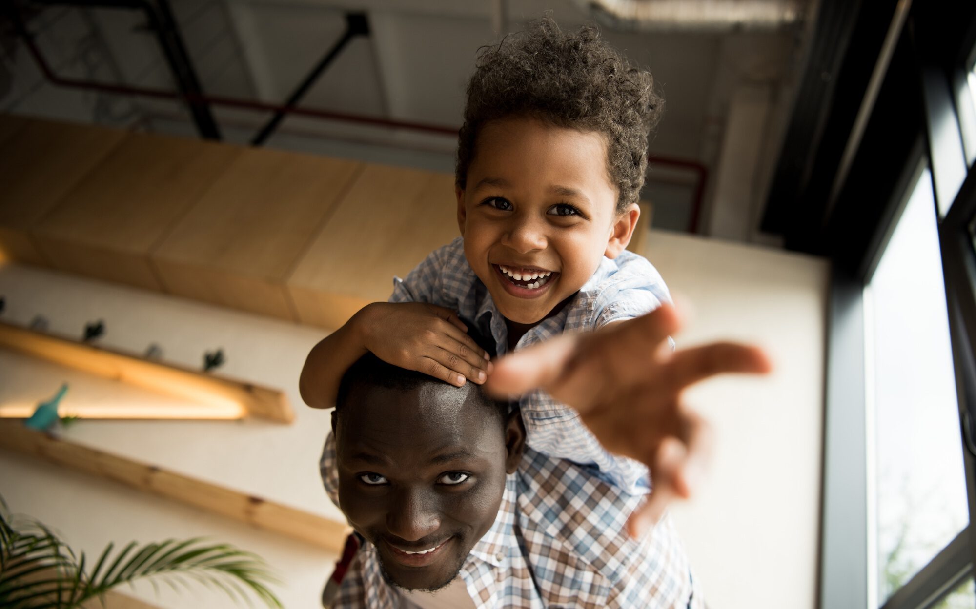 low angle view of beautiful happy african american father and child hugging and smiling at camera