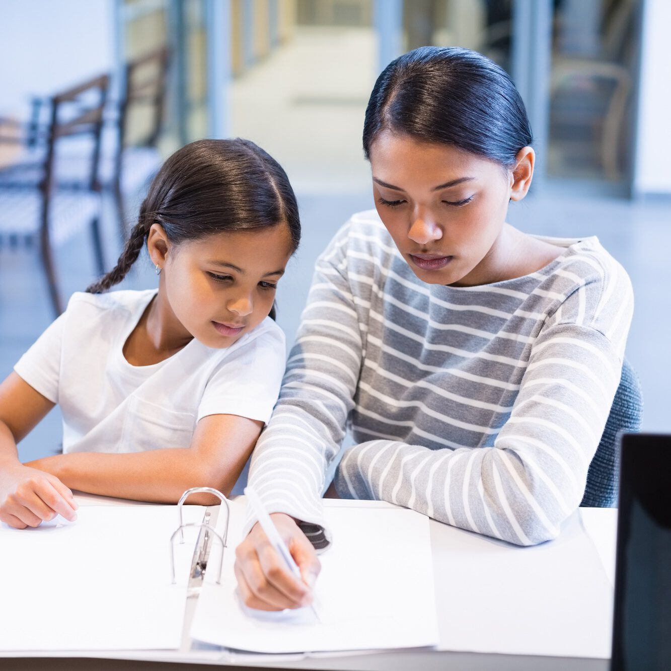 Mother and daughter filling out paperwork at counter